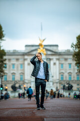 casual man exploring the majestic surroundings of buckingham palace on a cloudy day, a perfect...