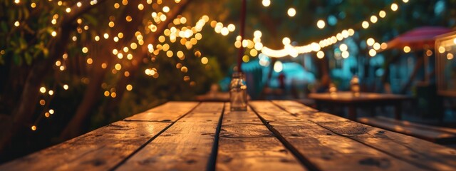 Empty Wood table top with decorative outdoor string lights hanging on tree in the garden at night time.  - obrazy, fototapety, plakaty