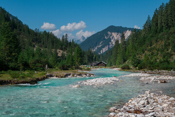 Fototapeta na wymiar Turquoise river Isar flowing through the Karwendel mountains during sunny blue sky day in summer, Tyrol Austria.