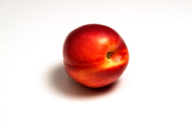 Whole nectarine with shadow on white background