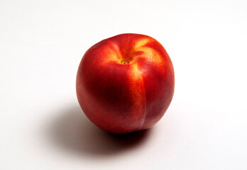 Whole nectarine with shadow on white background