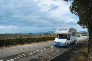 A camper stands on a road in Tuscany. Vineyards and landscapes of winter Italy.