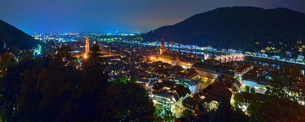 Heidelberg, Germany. Night high angle panoramic view of Heidelberg Old Town with Jesuit Church, Church of the Holy Spirit and Old Bridge (Karl Theodor Bridge) across the Neckar river. - obrazy, fototapety, plakaty