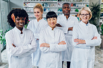 Portrait of five multiracial pharmacists in pharmacy.