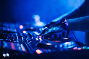 Cropped picture of dj hands performing live music on festival.