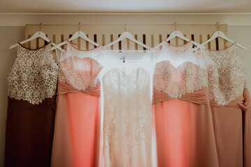Wedding dresses hanging on white hangers.