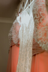 Details and close up of wedding dresses hanging on white hangers.