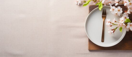 Beautiful table with utensils, napkin, blossom on cloth with copy space. Horizontal, above.