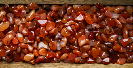 Carnelian stones on the wooden background. 