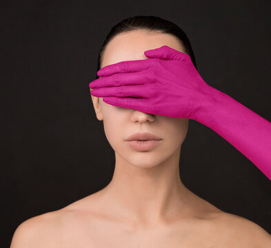 Glamor, woman's pink hand covers woman's face.