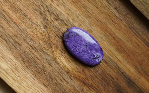 Piece of cut charoit on the wooden background. 