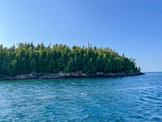 View of a green island from the lake shore