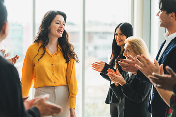 Successful businesswoman looking at camera with confidence while standing rounded with her coworker...