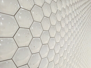 A wall tiled in white hexagons