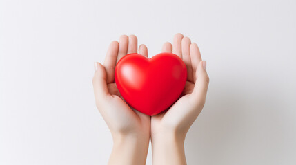 Hands hold a red volumetric heart on a white background. Heart close up.