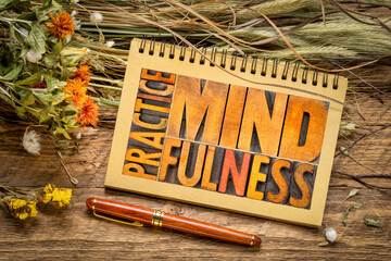 Practice mindfulness - word abstract in vintage letterpress wood type in a sketchbook, flat lay with dried flowers and grain stalks, self awareness concept