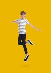 Fototapeta na wymiar Teenage boy jumping on golden background, full length portrait