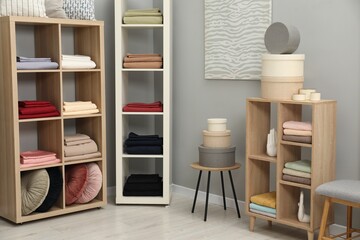 Different colorful bed linens and decorative boxes on display in home textiles store