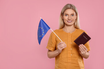 Immigration. Happy woman with passport and flag of European Union on pink background, space for text