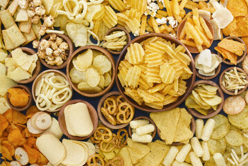 Colorful mix of salty snacks for beer varieties: chips and pretzels, onion rings and crackers....
