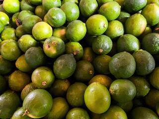 Top view of fresh green lemons as a background.