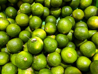 Top view of fresh green lemons as a background.