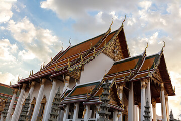 Wat Suthat in Bangkok, Thailand. Royal Temple constructed in 1807.  Blue sky, sunlit clouds overhead.
