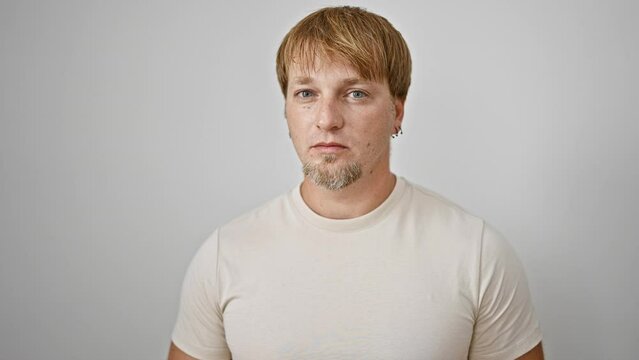 A portrait of a contemplative young adult caucasian man with blond hair and a beard against a white isolated background.