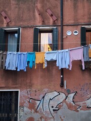 close up of laundry hanging on a clothesline in city, Italy