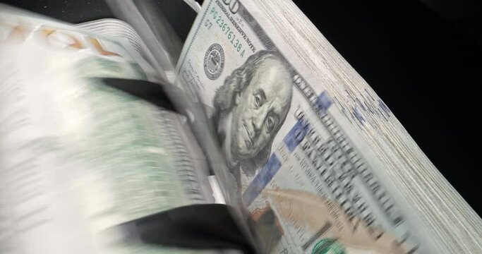 Device for counting, one hundred dollar bills rustle in stack. Special equipment for counting money. American dollar is being counted, smooth camera sliding. Machine counts money for financial use.