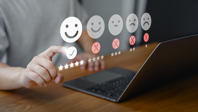 Customer touch virtual screen on happy smile face icon to give satisfaction in service. Business concept of customer satisfaction survey online review, assessment testimonial, rating and feedback.