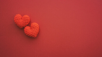 Two red hearts are placed on dark red paper with copy space. Love and Valentines day concept