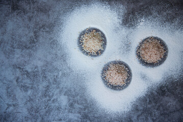 Organic Rice grains, Paddy rice and rice flour, Jasmine rice for cooking on concrete background, Top view flat lay, Copy space.