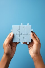 Blue puzzle pieces in hands