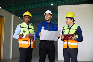 workers or engineers planning from work on blueprint drawing paper in the factory