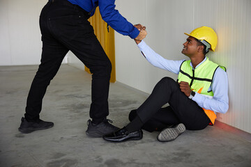 boss hands helping coworker to get up after a break in the factory