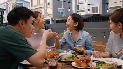 Mom enjoy thai meal cooking for family day meet talk home dining at dine table cozy patio. Group...