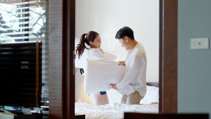 Young adult couple two asia people relax joy fun smile laugh spend good time play pillow fight war...