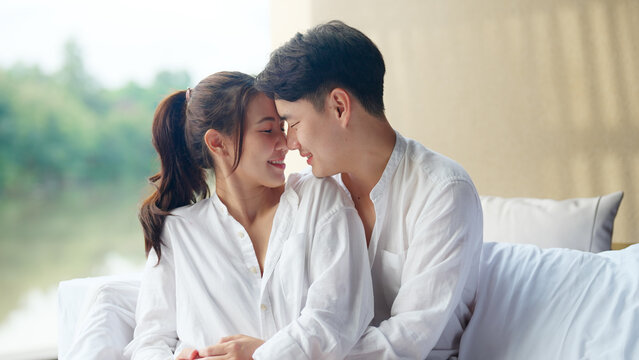 Young adult asia people fiance happy lover flirt fall in love nose lips kiss hug cuddle care trust. Sweet comfort touch newlywed asian couple life man smile look at woman face relax warm time dating.
