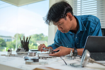 Engineer man designing and developing mechanical parts at his office.