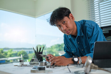 Engineer man designing and developing mechanical parts at his office.