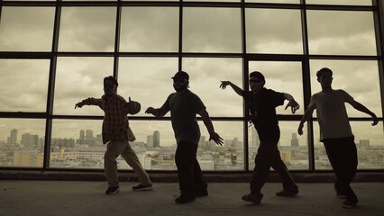 Silhouette shot of skilled choreographer group dancing together with sky scrapper, cityscape background. Young hipster team dancing performance. Sepia filter. Shadow. Outdoor sport 2024. Endeavor. - obrazy, fototapety, plakaty