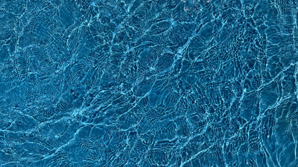 A serene, high-resolution texture of rippling blue water, ideal for backgrounds or aquatic-related...