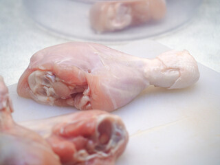 raw chicken thighs in white cutting board 