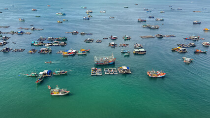 Fototapeta na wymiar An aerial view of a traditional fishing village with floating houses and various boats on a calm sea