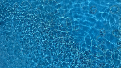 Crystal clear blue water surface with gentle ripples, suitable for concepts like tranquility, nature, or purity