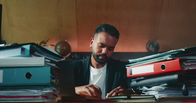Busy focused businessman, CEO works at office table full of paperwork documents organizing work process taking notes.