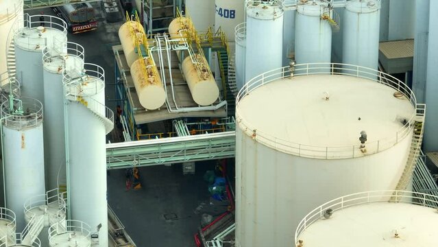Looking down, the lubricant plant emerges as a modern marvel, with its intricate network of tanks and pipelines, a testament to engineering excellence. 4K footage.
