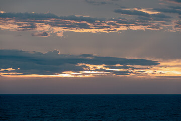vue sur la mer avec des nuages rétroéclairé dans le ciel lors d'un coucher de soleil 