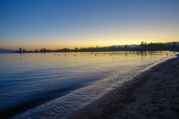 Colorful sunset on the sea. Mountain lake in the rays of the orange sun. Kyrgyzstan, Lake...